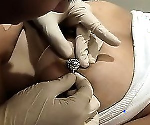 Busty bitch gets her nipples pierced and then on to her belly button